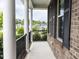 Covered porch with brick walls, white columns, and wrought iron railing overlooking lush greenery in a peaceful neighborhood at 437 Henmore Brook Dr Dr, Cary, NC 27519