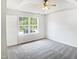 Bright bedroom with a large window, plush gray carpet, and fresh, neutral paint at 4509 Cobble Creek Ln, Raleigh, NC 27616