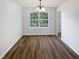 Dining room featuring laminate floors, a chandelier, and a large window at 4509 Cobble Creek Ln, Raleigh, NC 27616