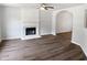 Bright living room with a white fireplace, hardwood floors, ceiling fan, and arched doorway at 4509 Cobble Creek Ln, Raleigh, NC 27616