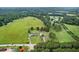 Scenic aerial shot of homes amidst vast green fields and dense forests, offering a serene countryside living experience at 4600 Smithfield Rd, Wendell, NC 27591
