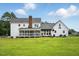 Expansive backyard featuring a white home with screened porch, lush lawn, and mature trees at 4600 Smithfield Rd, Wendell, NC 27591
