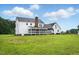 Spacious backyard with a white home featuring a screened porch, ample lawn space and a blue sky at 4600 Smithfield Rd, Wendell, NC 27591