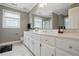Bright bathroom with white cabinets, double sinks, large mirrors, and natural light at 4600 Smithfield Rd, Wendell, NC 27591