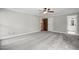 A carpeted bedroom features three doorways and two windows to let in plenty of natural light at 4600 Smithfield Rd, Wendell, NC 27591