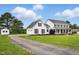 Two-story white farmhouse with black shutters and lush green lawn, next to long private driveway at 4600 Smithfield Rd, Wendell, NC 27591