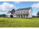 Two-story white farmhouse features black shutters, front porch, and extensive manicured green lawn at 4600 Smithfield Rd, Wendell, NC 27591