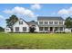 Two-story white farmhouse features black shutters, a front porch, and expansive manicured green lawn at 4600 Smithfield Rd, Wendell, NC 27591