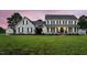 Charming two-story white farmhouse with black shutters and a lush green lawn, seen at twilight at 4600 Smithfield Rd, Wendell, NC 27591