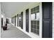 Inviting covered front porch showcasing white pillars, black shutters, and a wood-look floor at 4600 Smithfield Rd, Wendell, NC 27591