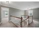 Carpeted upstairs hallway shows wooden railing, window, and doorways at 4600 Smithfield Rd, Wendell, NC 27591