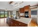 Kitchen island with cooktop, wooden cabinets, stainless appliances, and view of backyard at 4600 Smithfield Rd, Wendell, NC 27591