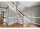 Elegant staircase features wood railings, white spindles, gray walls, and gleaming hardwood floors at 4600 Smithfield Rd, Wendell, NC 27591