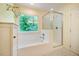 Bright bathroom features a soaking tub and shower with a glass enclosure at 507 Vatersay Dr, Apex, NC 27502