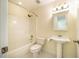 Cozy bathroom with tiled shower over tub, a toilet and pedestal sink at 507 Vatersay Dr, Apex, NC 27502