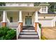 Inviting front porch with black steps, brick columns, and a light blue front door at 507 Vatersay Dr, Apex, NC 27502