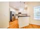 Bright kitchen with white cabinets, stainless steel appliances, and hardwood floors at 507 Vatersay Dr, Apex, NC 27502