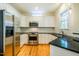 Well-lit kitchen featuring white cabinets, stainless steel appliances, and granite countertops at 507 Vatersay Dr, Apex, NC 27502