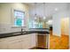Kitchen with stainless steel dishwasher, black granite countertops, and hardwood floors at 507 Vatersay Dr, Apex, NC 27502