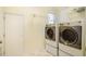 Well-equipped laundry room with modern washer and dryer units and overhead shelving at 507 Vatersay Dr, Apex, NC 27502