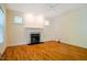 Spacious room with hardwood floors, large windows, and a cozy fireplace at 507 Vatersay Dr, Apex, NC 27502