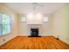 Open room with hardwood floors, large windows, and a cozy fireplace at 507 Vatersay Dr, Apex, NC 27502