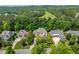 Aerial view of a luxurious home nestled among lush greenery and scenic views with neighboring houses at 671 Bear Tree Crk, Chapel Hill, NC 27517