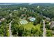 Aerial shot of community amenities, showcasing a pool, tennis court, and manicured landscaping, with a lake visible at 671 Bear Tree Crk, Chapel Hill, NC 27517
