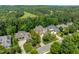Aerial view of the property in a suburban neighborhood with lush green trees and well-maintained lawns at 671 Bear Tree Crk, Chapel Hill, NC 27517