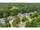 Aerial view of the property in a suburban neighborhood with lush green trees and well-maintained lawns at 671 Bear Tree Crk, Chapel Hill, NC 27517
