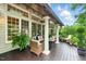 Spacious porch featuring wood flooring, pillars, comfortable seating, and views of the landscaped backyard at 671 Bear Tree Crk, Chapel Hill, NC 27517
