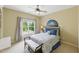This bedroom features neutral colored walls, a ceiling fan and a large window overlooking the yard at 671 Bear Tree Crk, Chapel Hill, NC 27517