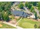 Aerial view of a clubhouse featuring outdoor seating, a well-kept lawn, and ample parking at 671 Bear Tree Crk, Chapel Hill, NC 27517