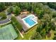 Aerial view showcasing the community pool with chairs, umbrellas, and surrounding tennis courts at 671 Bear Tree Crk, Chapel Hill, NC 27517