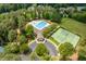Aerial view featuring a community pool with an attached clubhouse and meticulously maintained tennis courts at 671 Bear Tree Crk, Chapel Hill, NC 27517