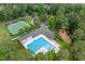 Aerial view of a community pool and surrounding tennis court, playground, and landscaping at 671 Bear Tree Crk, Chapel Hill, NC 27517