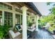 Relaxing covered porch featuring columns, ceiling fans, plenty of seating, and outdoor fireplace at 671 Bear Tree Crk, Chapel Hill, NC 27517
