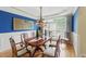 Formal dining room featuring a large window, chandelier, hardwood floors, and bold blue accent wall at 671 Bear Tree Crk, Chapel Hill, NC 27517