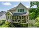 Exterior view of a home showcasing a spacious deck with outdoor seating, pergola, and manicured landscaping at 671 Bear Tree Crk, Chapel Hill, NC 27517