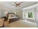 Tranquil bedroom with tray ceilings, neutral paint, large bed, and a window nook with backyard views at 671 Bear Tree Crk, Chapel Hill, NC 27517