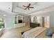 Spacious bedroom featuring tray ceilings, a ceiling fan, an ensuite bath, and built-in shelving at 671 Bear Tree Crk, Chapel Hill, NC 27517