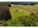 Overhead view of a secluded home with a long private drive and outbuildings surrounded by mature trees at 6916 Morrow Mill Road, Chapel Hill, NC 27516