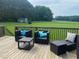 An outdoor deck with wicker furniture overlooking a lush lawn and distant shed at 6916 Morrow Mill Road, Chapel Hill, NC 27516