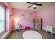 Cozy pink bedroom decorated with floral accents, featuring a dollhouse and ample space for toys at 6916 Morrow Mill Road, Chapel Hill, NC 27516