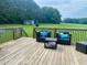 Relaxing deck area with wicker seating, decorative pillows, and a tranquil view of the surrounding landscape at 6916 Morrow Mill Road, Chapel Hill, NC 27516