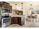 A kitchen featuring granite countertops, stainless steel appliances, hardwood flooring, and an eat-in dining area at 6916 Morrow Mill Road, Chapel Hill, NC 27516