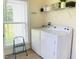 A laundry room features a window, shelving, a washer, and a dryer at 6916 Morrow Mill Road, Chapel Hill, NC 27516