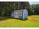 This charming shed has a barn-style door and freshly painted exterior in a well manicured yard at 6916 Morrow Mill Road, Chapel Hill, NC 27516