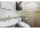 Bathroom featuring a modern sink and vanity, complemented by a glass block wall and dark accent wall cabinet at 712 Beaver Dam Rd, Raleigh, NC 27607