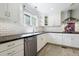 Renovated kitchen featuring white cabinetry, stone countertops, and stainless steel dishwasher at 712 Beaver Dam Rd, Raleigh, NC 27607